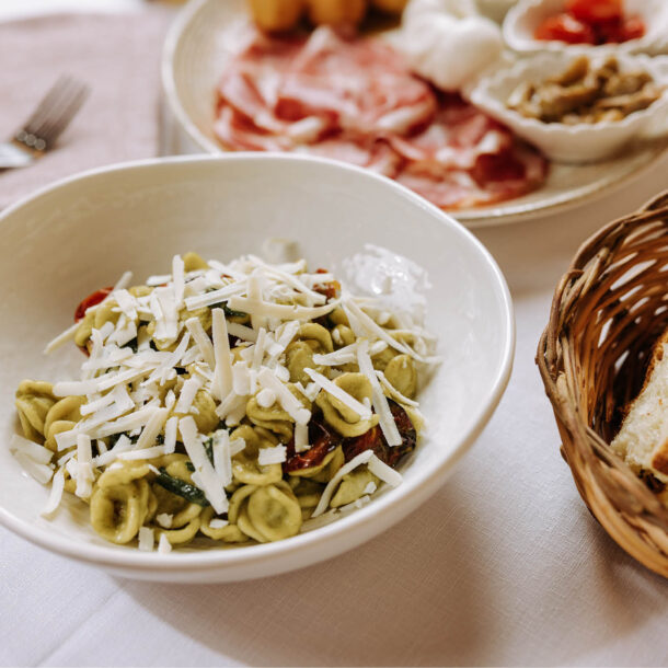 Orecchiette con crema verde, pomodorini e formaggio grattugiato, con un cestino di pane